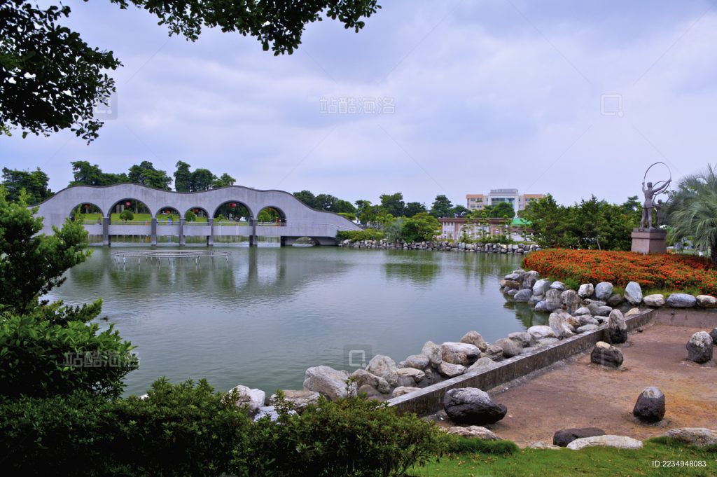 这是台湾台中市丰乐雕塑公园的人工湖与景观拱桥，右侧的雕塑也是公园的代表性展品之一